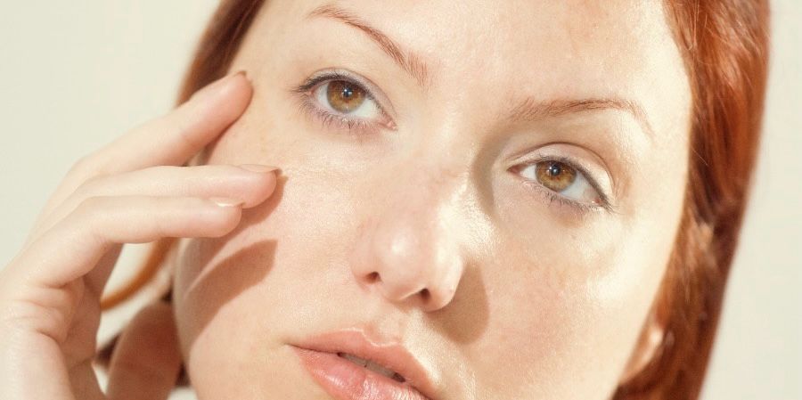 Woman touching skin to tell if her skincare is working